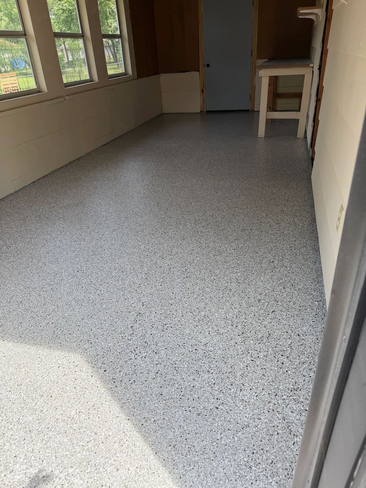 Finished flake floor in a garage with wood walls and hanging tools